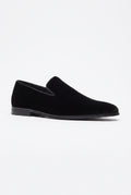 A single black velvet slip-on loafer shown in a side profile view against a plain white background.