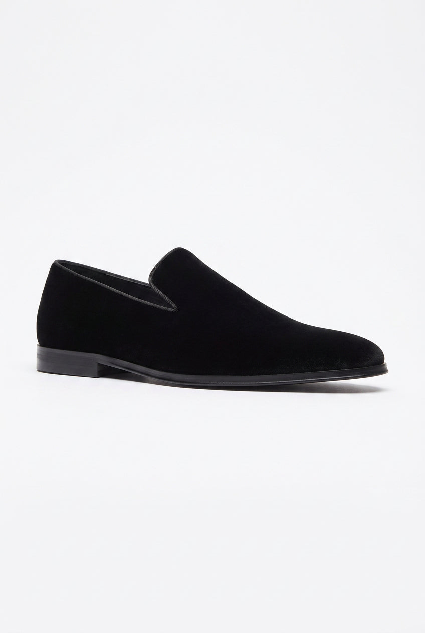 A single black velvet slip-on loafer shown in a side profile view against a plain white background.